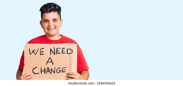 Little boy kid holding we need a change banner looking positive and happy standing and smiling with a confident smile showing teeth  - Powered by Shutterstock