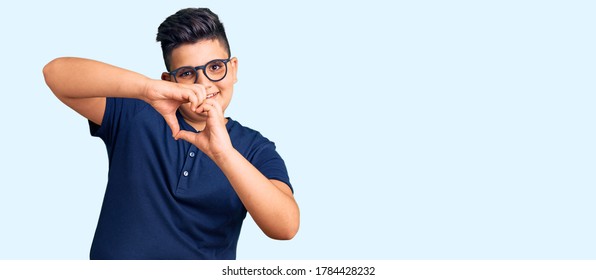 Little Boy Kid Wearing Casual Clothes And Glasses Smiling In Love Doing Heart Symbol Shape With Hands. Romantic Concept. 