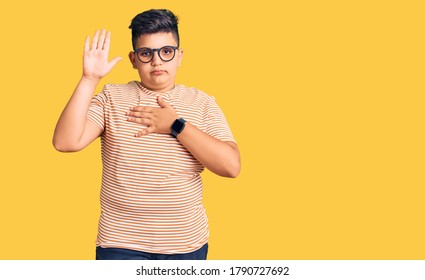 Little Boy Kid Wearing Casual Clothes And Glasses Swearing With Hand On Chest And Open Palm, Making A Loyalty Promise Oath 