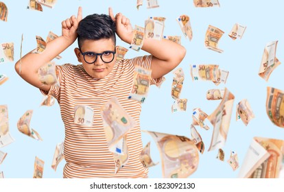 Little Boy Kid Wearing Casual Clothes And Glasses Doing Funny Gesture With Finger Over Head As Bull Horns