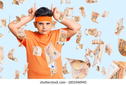 Little Boy Kid Wearing Sportswear Doing Funny Gesture With Finger Over Head As Bull Horns