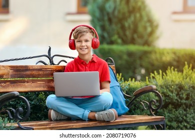 Little boy with laptop listening to music in park - Powered by Shutterstock