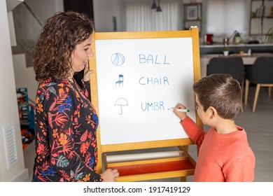 Little boy learning english with his mother at home