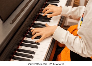 Little boy learning to play the piano. Close-up of a child's hands playing the piano. - Powered by Shutterstock