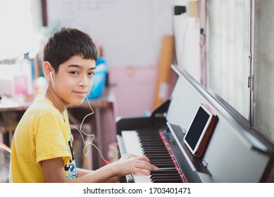 Little boy learning practicing piano online digital tablet - Powered by Shutterstock