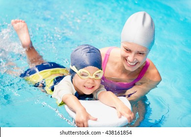 Little Boy Learning To Swim With Instructor