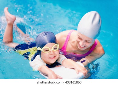 Little Boy Learning To Swim With Swimming Instructor