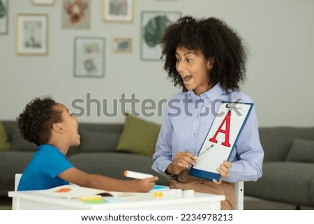 A little boy learns the letter A with a private English tutor during a lesson at home