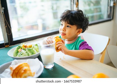 Little Boy Lick His Lip After Bite The Sausage Croissant.