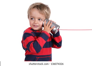 Little boy listening through a tin can phone connected by string, concept for communication