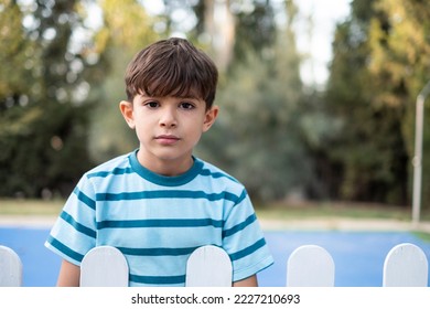 Little boy looking at camera behind the fences - Powered by Shutterstock