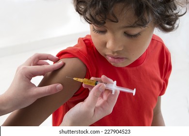 little boy looking at his arm, while receiving vaccine - Powered by Shutterstock