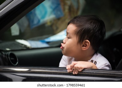 Little Boy Looking Left Car Door Mirror And Make A Playful Face Wrapped Up The Mouth.