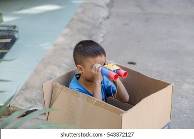 Little boy looking through binocular when playing at home