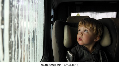 Little boy looking through misted window. Cleaning Car Using High Pressure Water. Car wash, car wash foam water. From inside the car. - Powered by Shutterstock