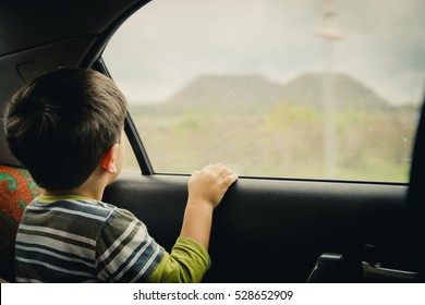 Little boy looking through window