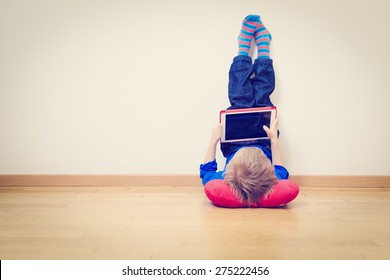 little boy looking at touch pad at home