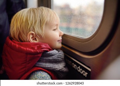 Little Boy Looks Out The Window Of The Car In The Subway In New York. Family Travel With Children.