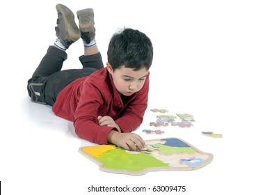 little boy lying on the floor making puzzles