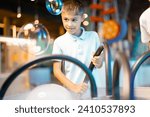 Little boy make soap bubbles, while playing together and having fun in a science museum. Concept of children