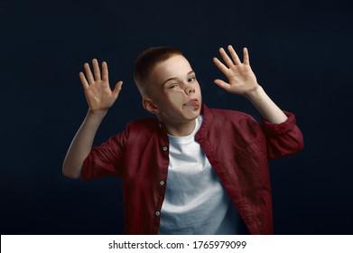 Little Boy Makes Face Leaning Against The Glass