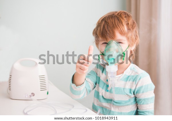 Little\
boy making inhalation with nebulizer at home.\
\
