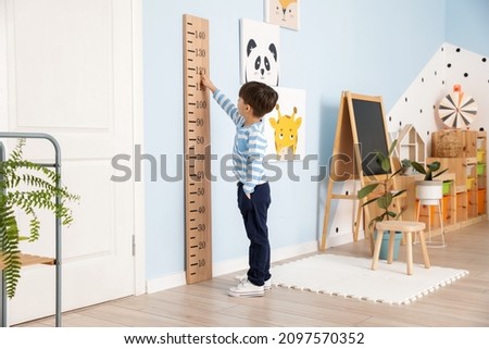 Little boy measuring height at home