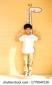 Little Boy Measuring His Height At Home