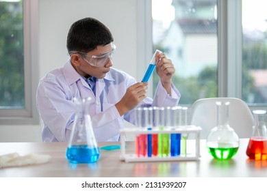 Little boy mixes chemicals in beakers. kids with test tube making experiment at school laboratory. - Powered by Shutterstock
