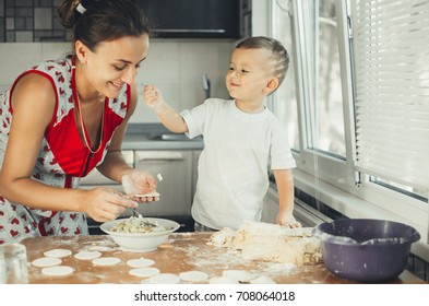 Little Boy With Mom In The Kitchen Preparing Flour From Those Of The Test Dish, Dumplings