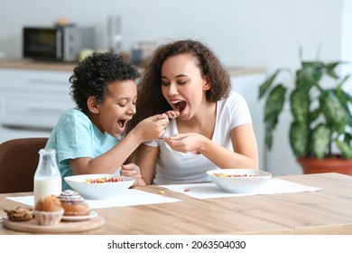 Little boy with mother eating cornflakes at home - Powered by Shutterstock