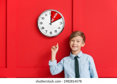 Little boy near clock with timer for 10 minutes on color background. Time management concept - Shutterstock ID 1982814578
