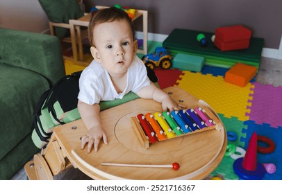 Little boy with neurodevelopmental disorders participates in music therapy using a xylophone, promoting his physical rehabilitation in a colorful playroom - Powered by Shutterstock