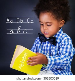 Little boy on language lesson, holding in hands alphabet, learning letters and spelling, preparing to go to first class  