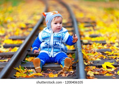 Little boy on the railway in the autumn park