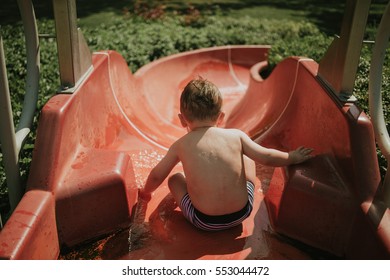 Little Boy On Red Waterslide