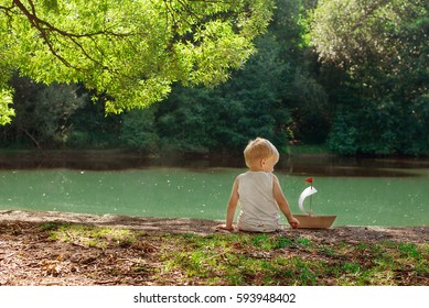 Little Boy With A Paper Boat In Summer Park Near Pond