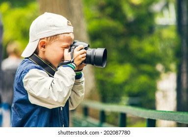 Little boy with photo camera makes a shoot