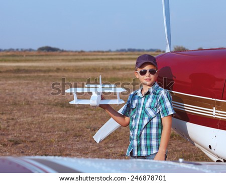 Little boy pilot with handmade plane at the airport 