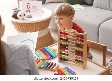 Little boy playing with abacus at psychologist's office. World Autism Awareness Day - Powered by Shutterstock