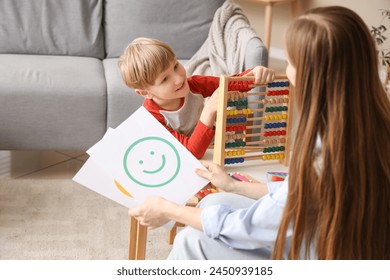 Little boy playing with abacus at psychologist's office. World Autism Awareness Day - Powered by Shutterstock