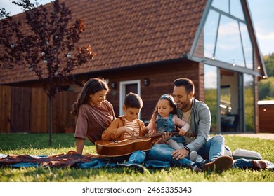 Little boy playing acoustic guitar during family camping. Copy space.  - Powered by Shutterstock