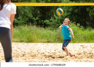 LITTLE BOY PLAYING BEACH VOLLEYBALL