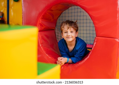 Little Boy Is Playing In Children's Play Center Among Huge Soft Blocks.