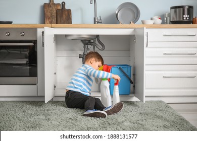 Little Boy Playing With Cleaning Supplies At Home