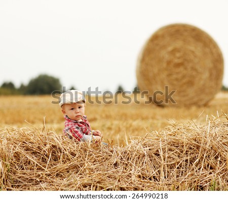 a little boy playing in a cowboy hat on the nature