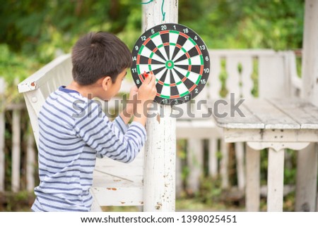 Little boy playing darts board family outdoor activity 
