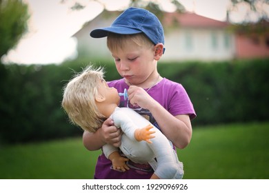 little boy playing with a doll in nature 2021