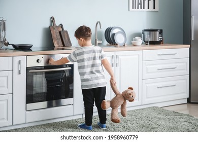 Little boy playing with electric oven at home