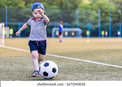 a little boy playing football on the field